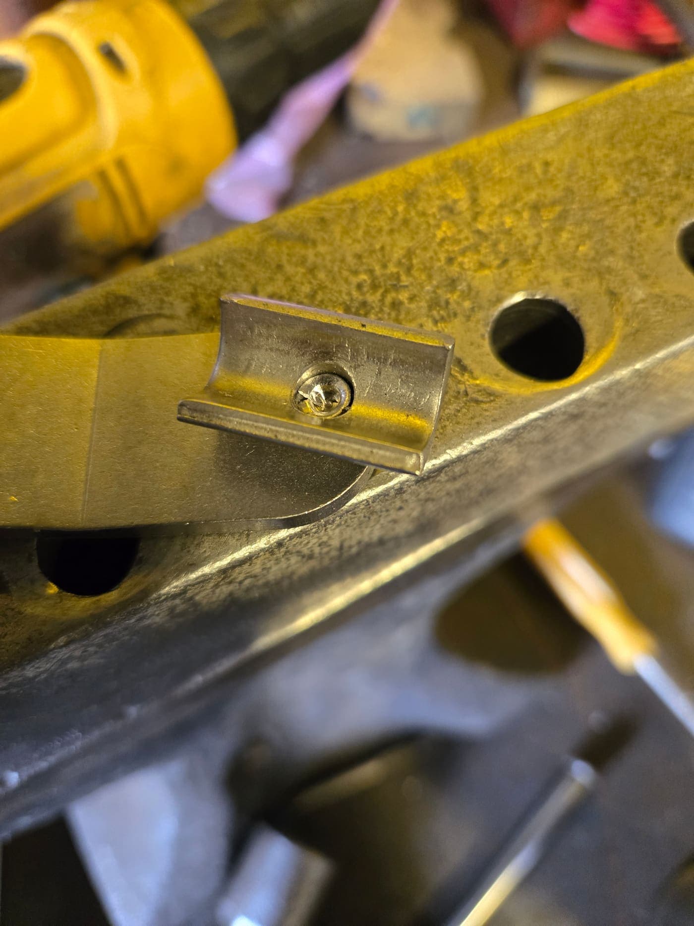 Powder-coated steel bracket with installed fastener on a finished assembly