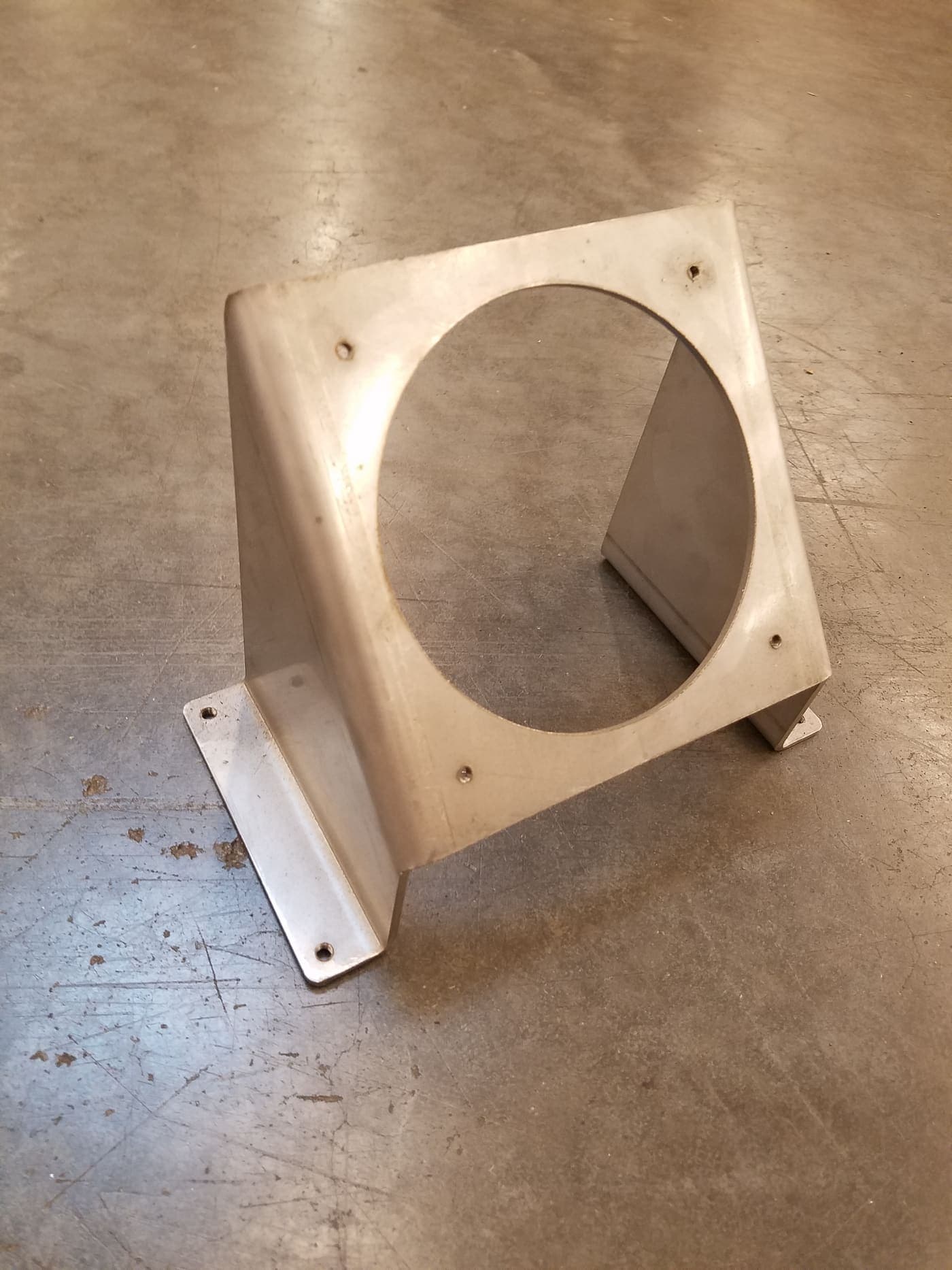 Welded stainless steel bracket with a large bored face and formed mounting feet